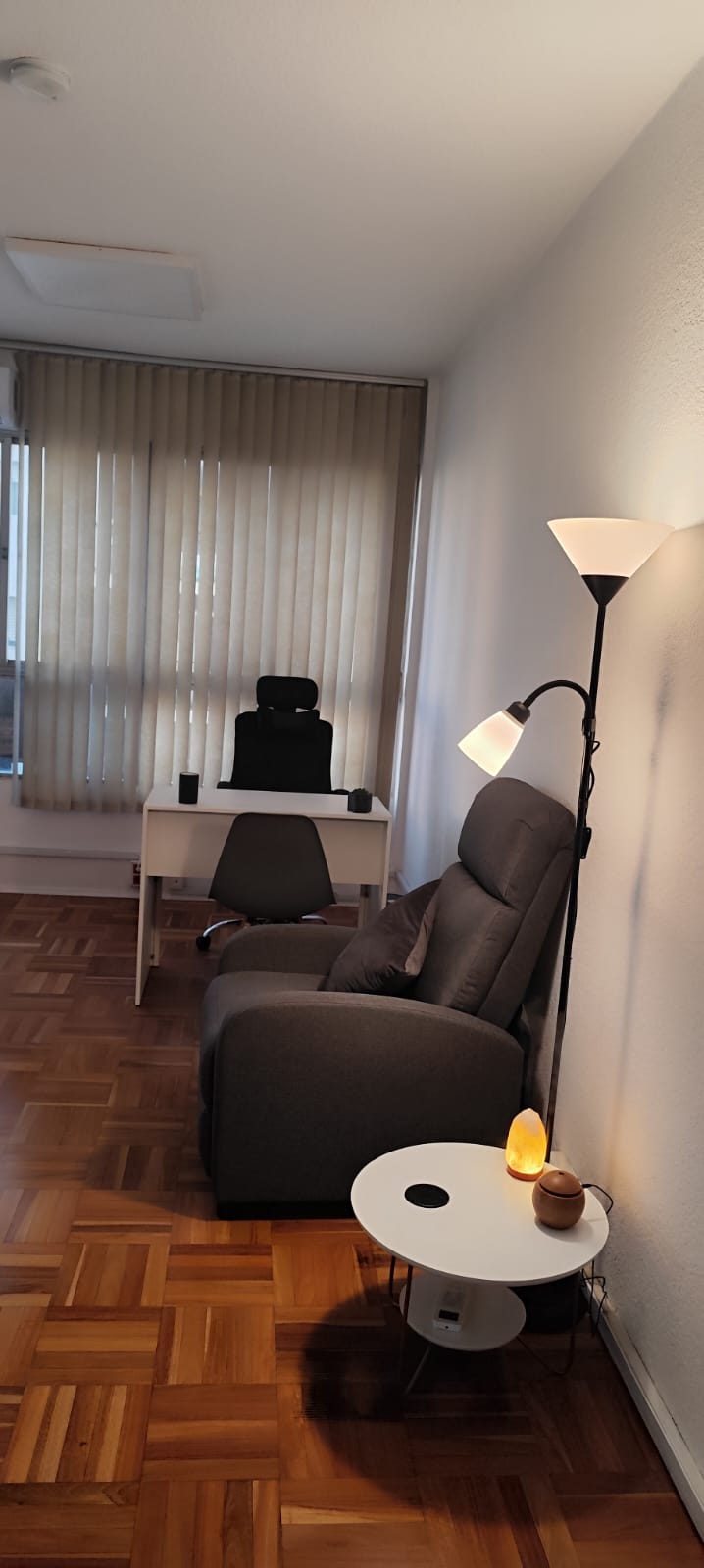 Consultorio con sillones, mesa y luz natural